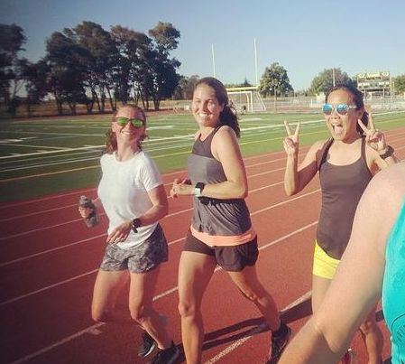 three women running around a track