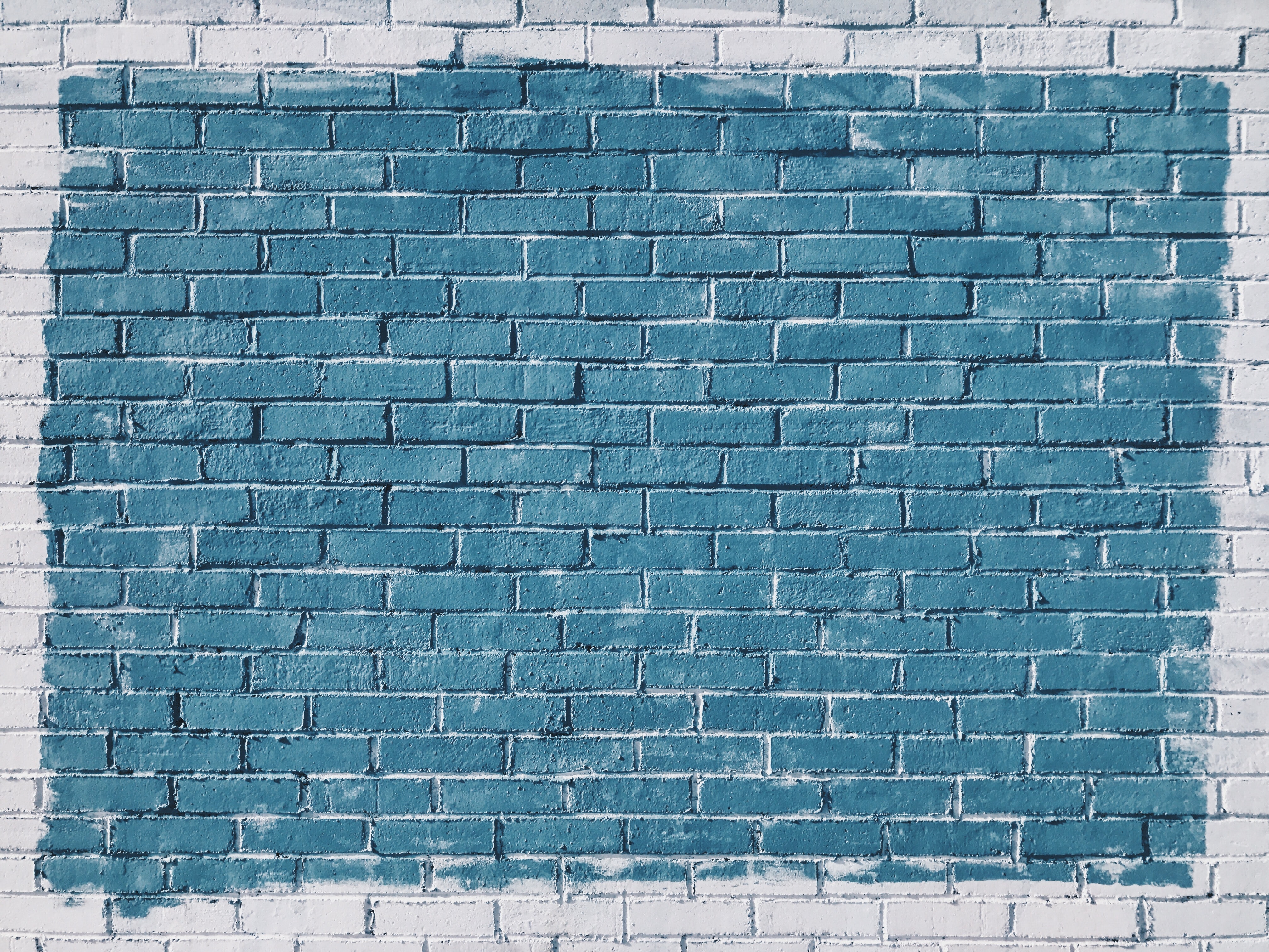 white brick wall, with blue paint on it